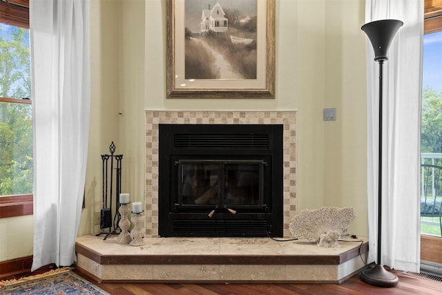 1905 W Olive St, Marshalltown, IA 50158 - detailed view of a tile fireplace, baseboards, and wood finished floors