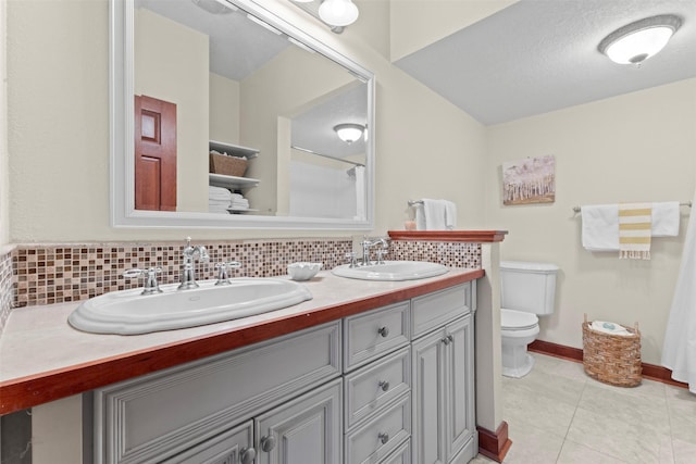 1905 W Olive St, Marshalltown, IA 50158 - full bathroom with toilet, decorative backsplash, double vanity, tile patterned flooring, and baseboards