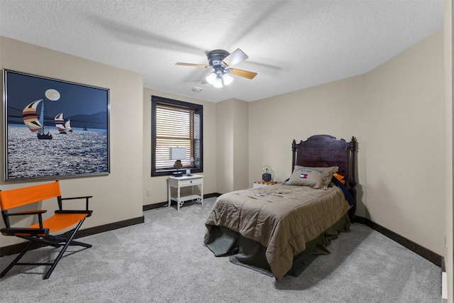 1905 W Olive St, Marshalltown, IA 50158 - carpeted bedroom with baseboards, a textured ceiling, and a ceiling fan
