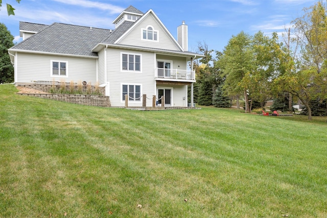1905 W Olive St, Marshalltown, IA 50158 - back of house featuring a balcony, a lawn, and a chimney