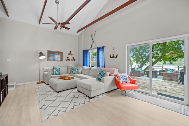 living area with light wood-type flooring, baseboards, high vaulted ceiling, and a ceiling fan