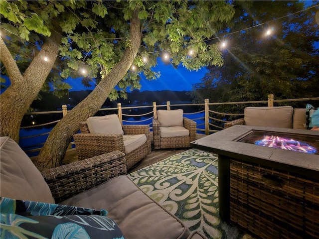 patio at night with an outdoor living space with a fire pit