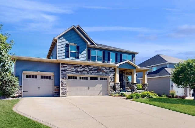 craftsman-style house with a front yard, stone siding, and concrete driveway