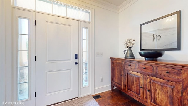 foyer with baseboards, visible vents, dark wood-style flooring, and ornamental molding