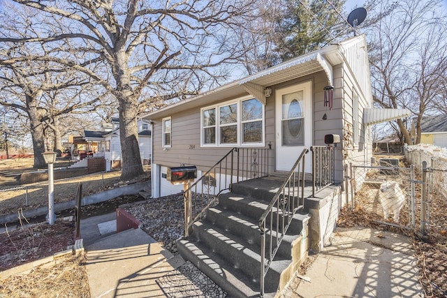 view of front of home featuring entry steps, fence, and an attached garage