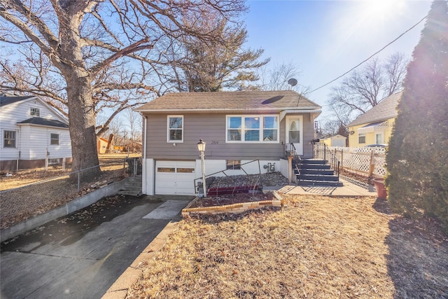 view of front of home featuring driveway, an attached garage, and fence