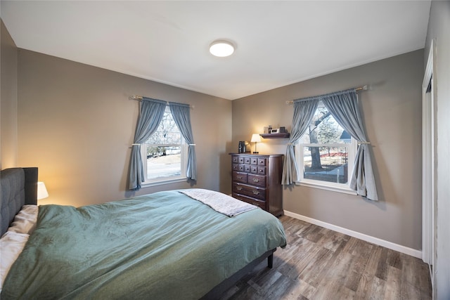 bedroom with baseboards and wood finished floors