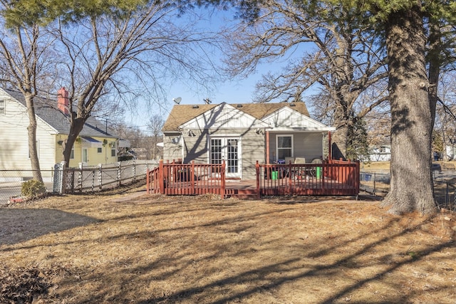 rear view of property featuring french doors, fence, a chimney, and a wooden deck