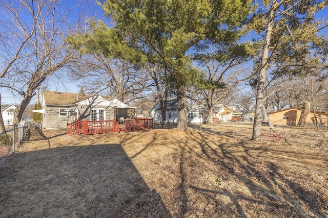 view of yard featuring a residential view, fence, and a deck