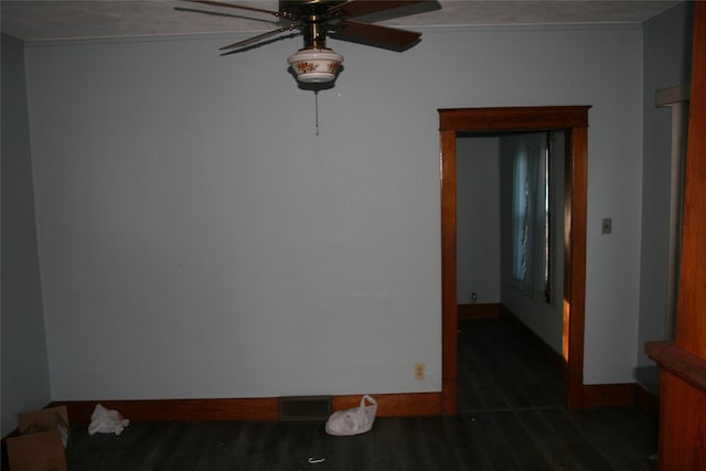 spare room with a ceiling fan, baseboards, and wood finished floors