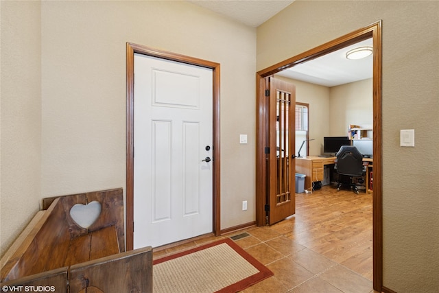 foyer entrance with visible vents, baseboards, and light tile patterned floors