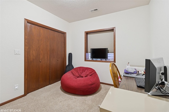 home office with a textured ceiling, carpet floors, visible vents, and baseboards