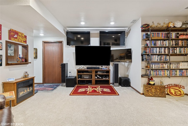 living room featuring carpet floors, a glass covered fireplace, baseboards, and recessed lighting