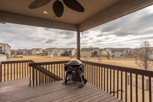 deck with a yard, area for grilling, a residential view, and a ceiling fan