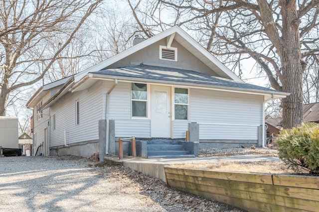 view of front of property featuring entry steps, driveway, and a chimney