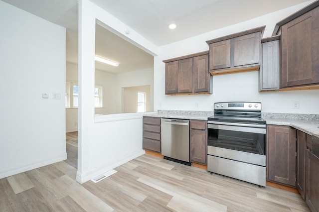 kitchen with appliances with stainless steel finishes, light countertops, visible vents, and light wood-style flooring