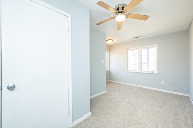 spare room featuring ceiling fan, carpet flooring, visible vents, and baseboards