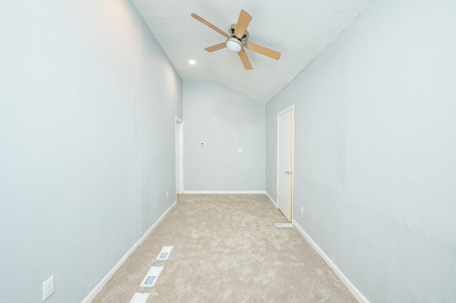 unfurnished room featuring ceiling fan, light carpet, visible vents, baseboards, and vaulted ceiling