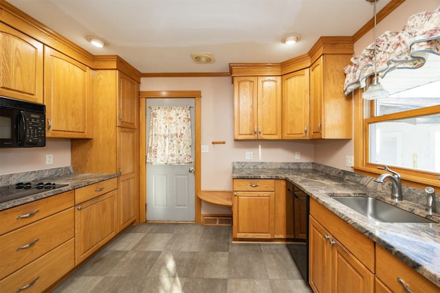 kitchen with dark stone counters, black appliances, a sink, and visible vents