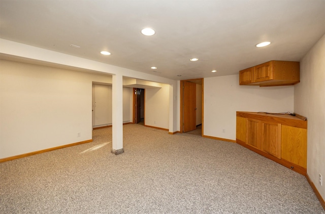 finished below grade area featuring recessed lighting, light carpet, and baseboards