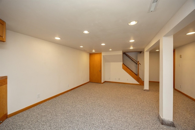 finished below grade area with light carpet, recessed lighting, visible vents, and baseboards