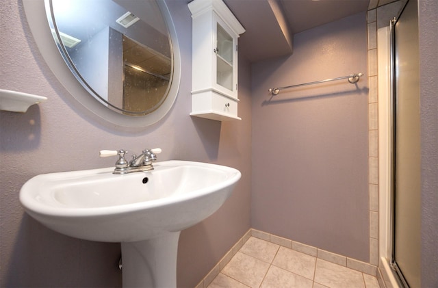 full bathroom with tile patterned flooring, a shower stall, and baseboards