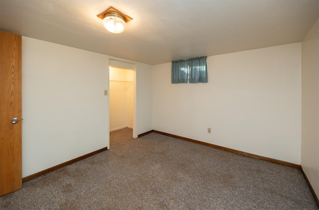 unfurnished room featuring carpet and baseboards