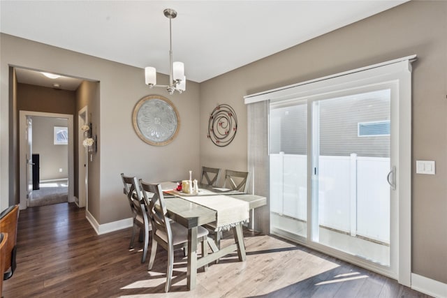 dining room featuring a notable chandelier, wood finished floors, and baseboards