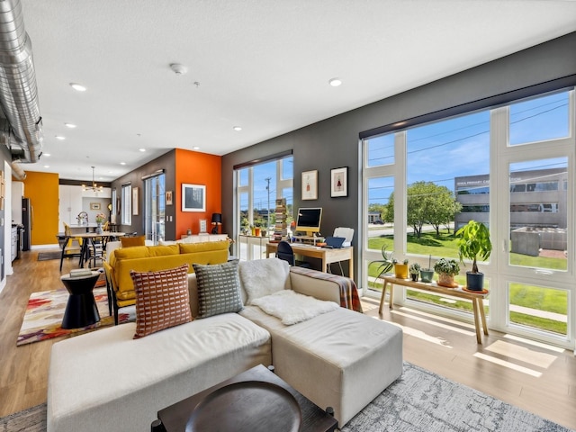 living room featuring an inviting chandelier, recessed lighting, and light wood finished floors