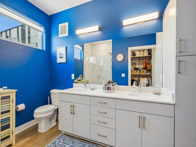 450 SW 7th St Unit 210, Des Moines, IA 50309 - full bath with a marble finish shower, toilet, double vanity, wood finished floors, and baseboards