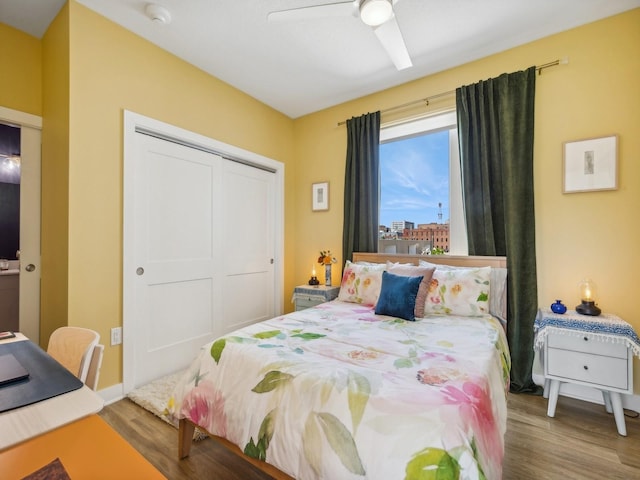450 SW 7th St Unit 210, Des Moines, IA 50309 - bedroom featuring wood finished floors, a closet, a ceiling fan, and baseboards