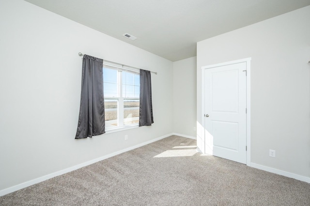 carpeted empty room featuring visible vents and baseboards