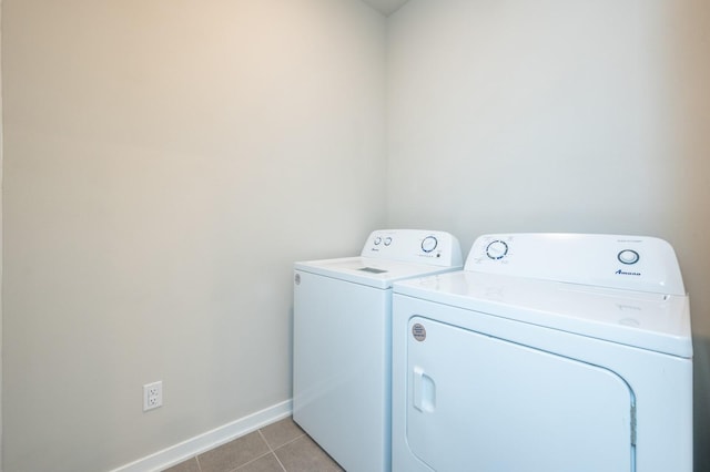 washroom featuring laundry area, light tile patterned floors, baseboards, and separate washer and dryer