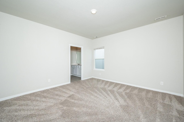 carpeted empty room with visible vents and baseboards