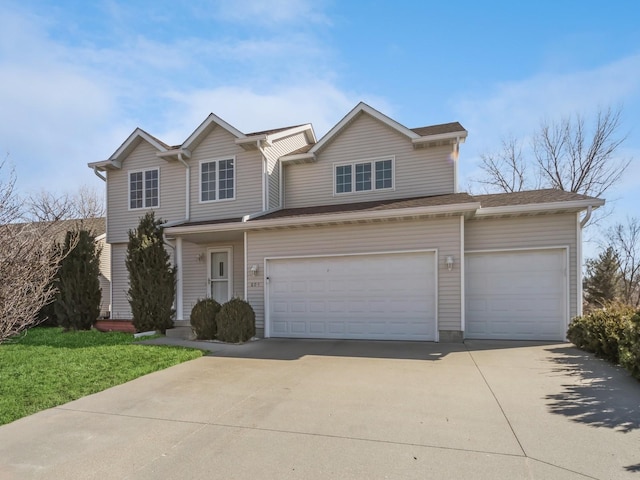 traditional-style home featuring an attached garage and concrete driveway