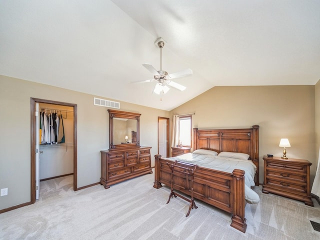 bedroom featuring a closet, light colored carpet, visible vents, vaulted ceiling, and baseboards