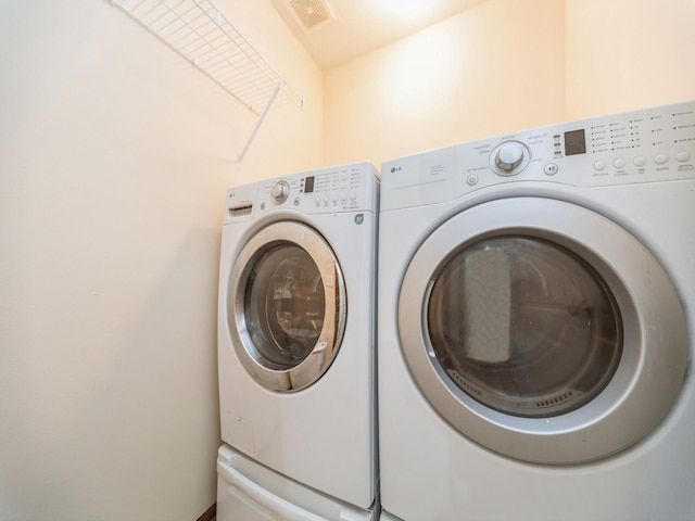 laundry area featuring laundry area, visible vents, and separate washer and dryer