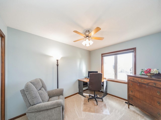 office featuring ceiling fan, baseboards, and light colored carpet