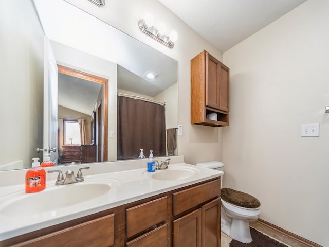 604 NW 8th St, Grimes, IA 50111 - full bathroom with a sink, vaulted ceiling, toilet, and double vanity
