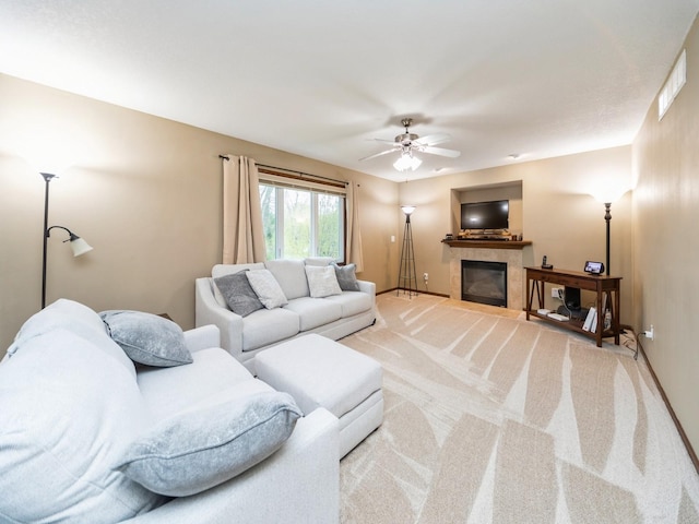 604 NW 8th St, Grimes, IA 50111 - living room with a ceiling fan, visible vents, a fireplace, baseboards, and light carpet