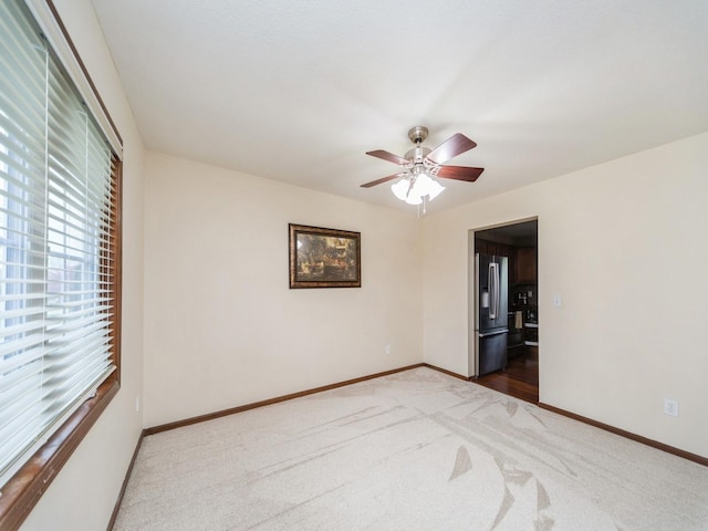 604 NW 8th St, Grimes, IA 50111 - empty room with baseboards, a ceiling fan, carpet flooring, and a wealth of natural light