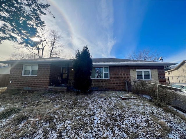 rear view of property with brick siding and fence