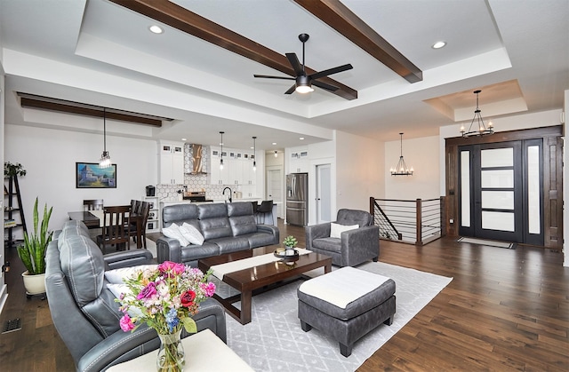 living area with beam ceiling, a tray ceiling, dark wood-style flooring, and recessed lighting