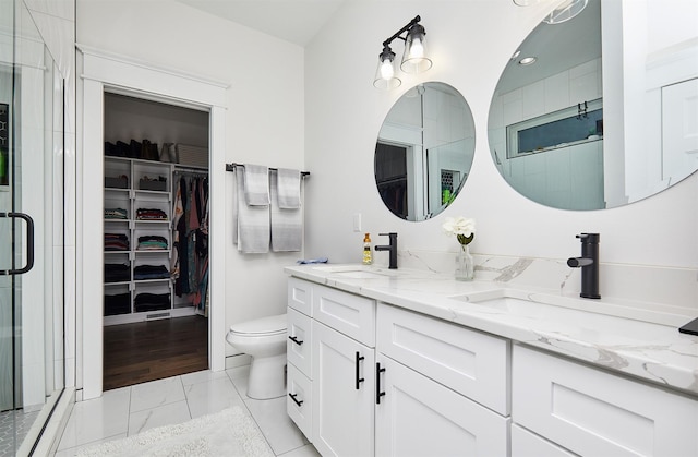 full bath with a spacious closet, a sink, and a shower stall