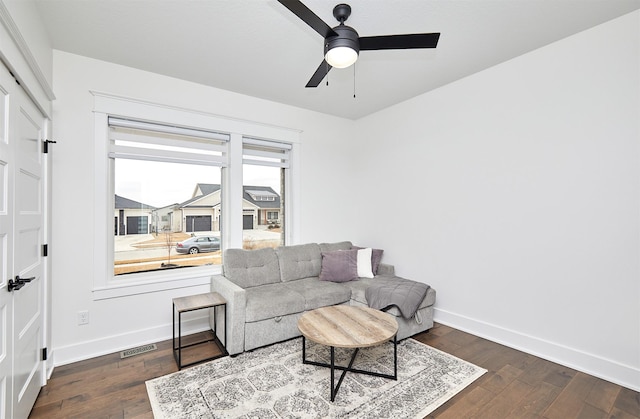 living area with wood-type flooring, visible vents, ceiling fan, and baseboards