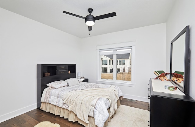 bedroom with ceiling fan, dark wood finished floors, and baseboards