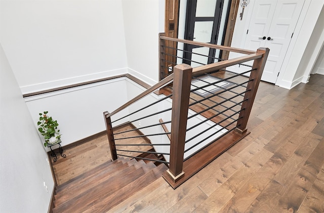 staircase with hardwood / wood-style flooring and baseboards