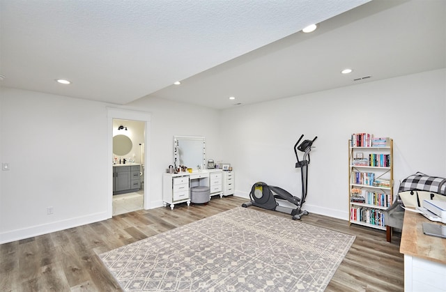 interior space with recessed lighting, visible vents, a textured ceiling, wood finished floors, and baseboards