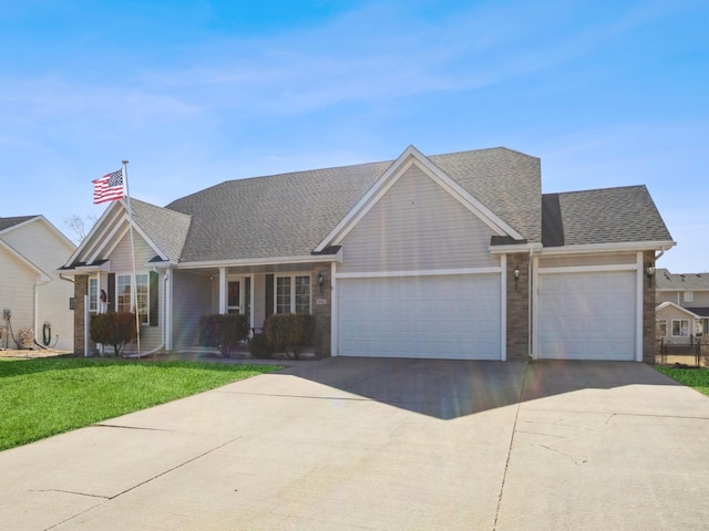 view of front of home featuring driveway, a shingled roof, an attached garage, and a front yard