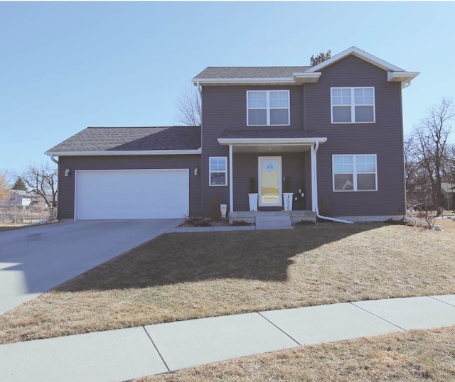 traditional home with concrete driveway, a front lawn, an attached garage, and a shingled roof